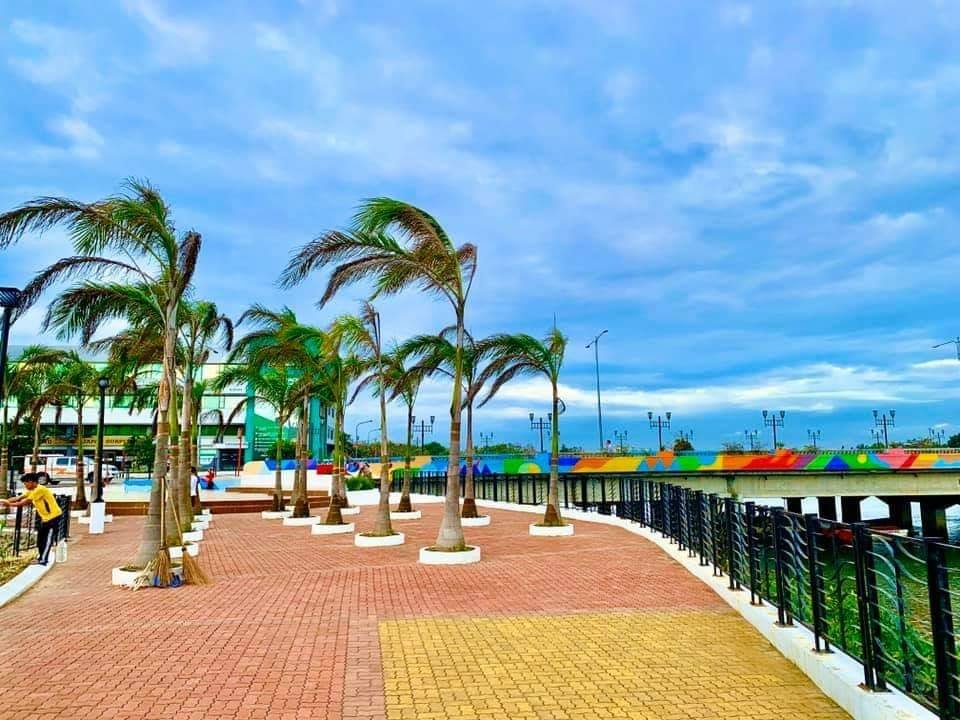 Scenic view of the Iloilo River Esplanade, a popular riverside promenade in Iloilo City, featuring lush greenery and a serene walkway.