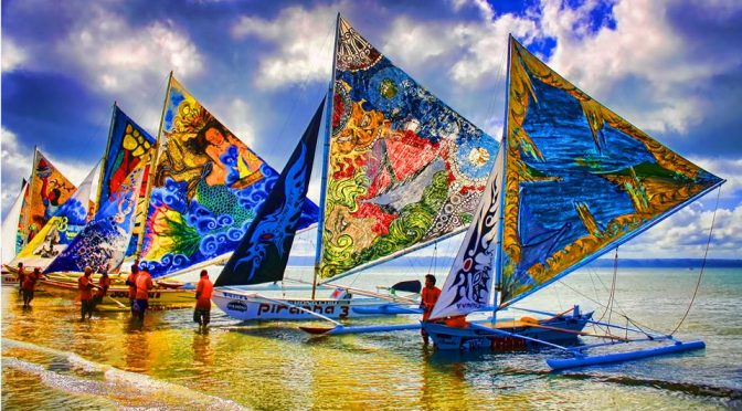 Colorful sailboats racing during the Paraw Regatta Festival in Iloilo, Philippines, showcasing the vibrant maritime culture of the region.