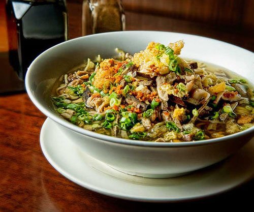 Close-up of a bowl of La Paz Batchoy, a traditional Filipino noodle soup from Iloilo, featuring rich broth, pork, and chicharon.